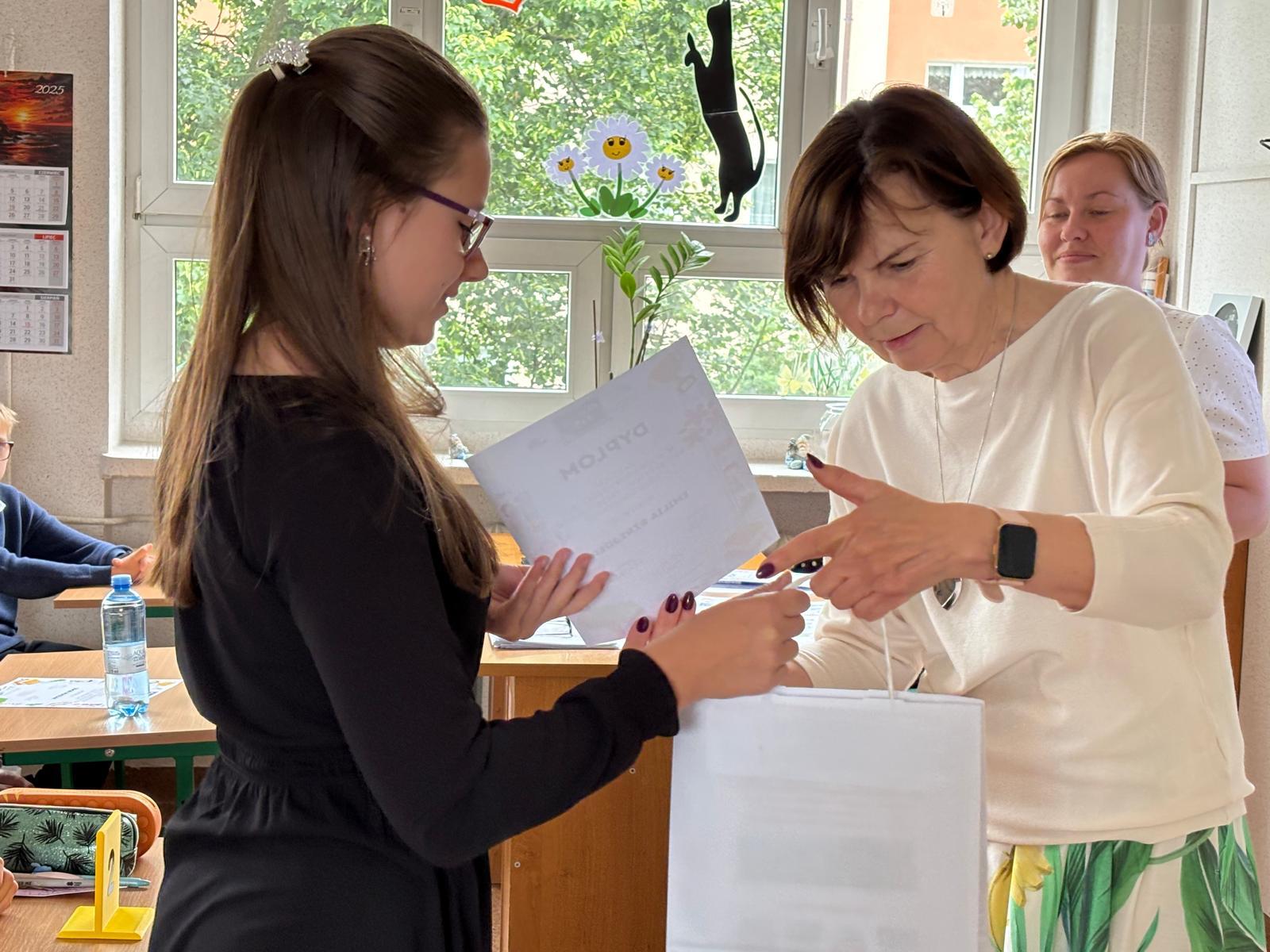 Dziewczyna odbierająca nagrody z rąk organizatorki