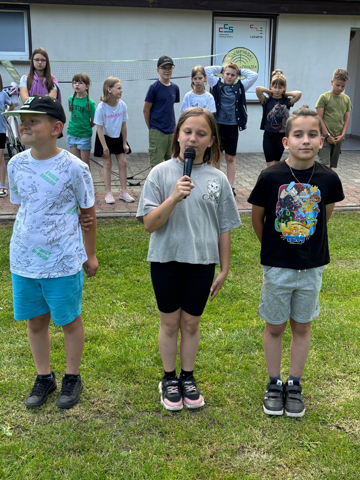 Grupa trzech uczniów z mikrofonem