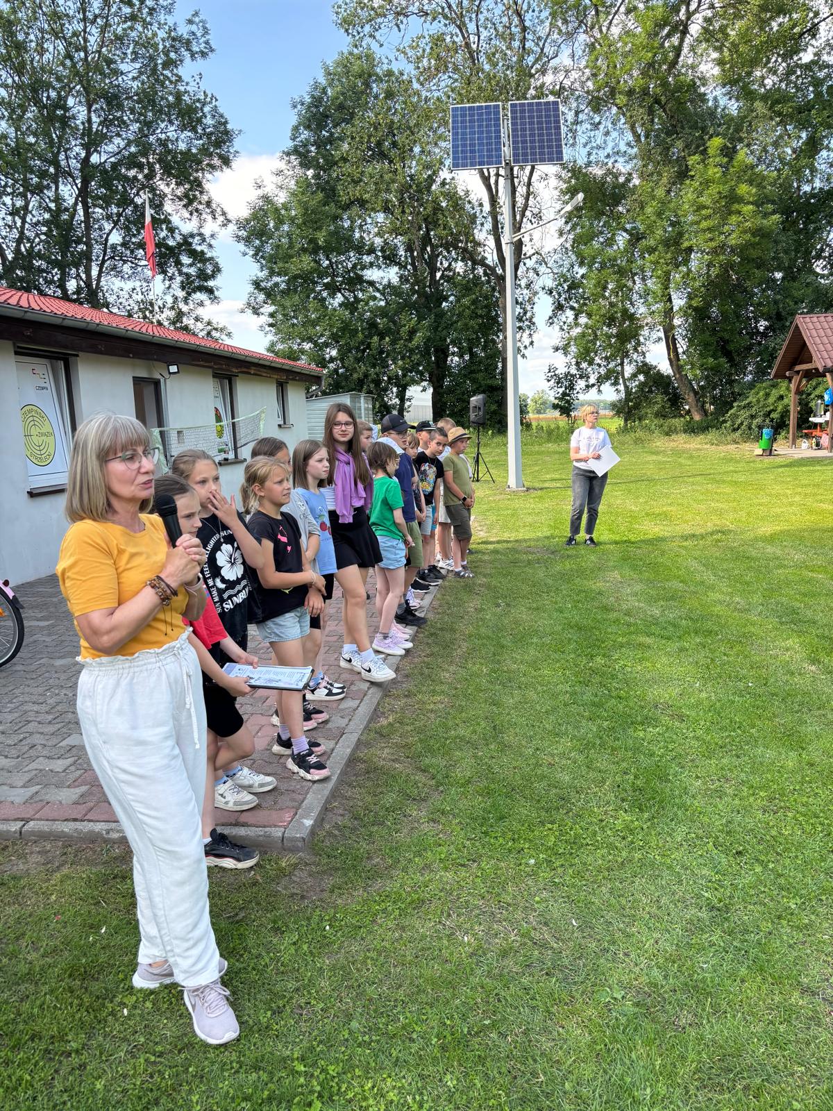 Grupa uczestników po lewej prowadząca mówiąca do mikrofonu