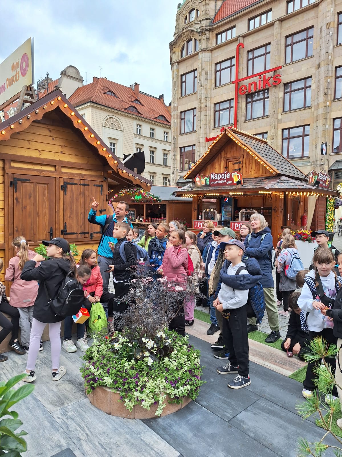 Zdjęcie uczestnikow na rynku przy stoiskach gastronomicznych 